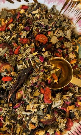 A close-up of loose-leaf ritual tea with a gold spoon